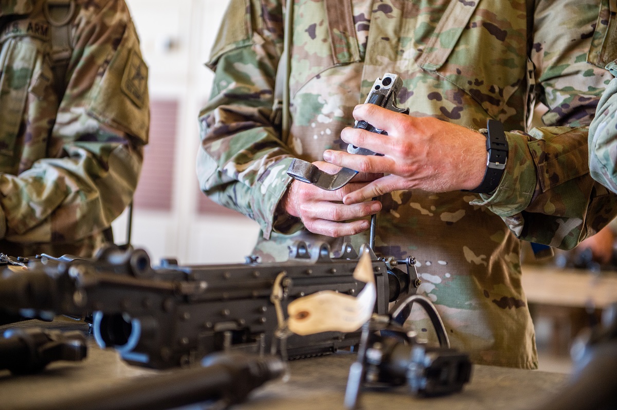 Braaten practices assembling and disassembling the M2A1 .50 Caliber Machine Gun. Trainees are required to break the gun down into eight major parts, adjust head space and timing, and reassemble the weapon.