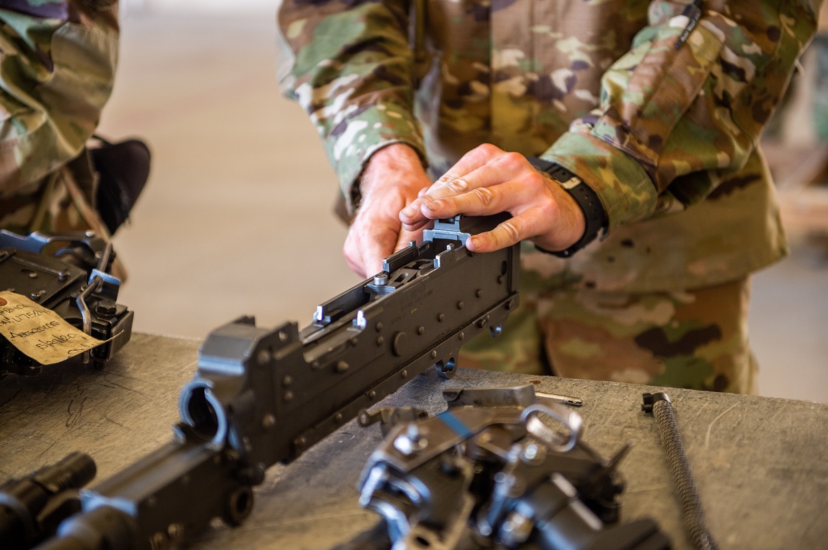 Braaten practices assembling and disassembling the M2A1 .50 Caliber Machine Gun. Trainees are required to break the gun down into eight major parts, adjust head space and timing, and reassemble the weapon.