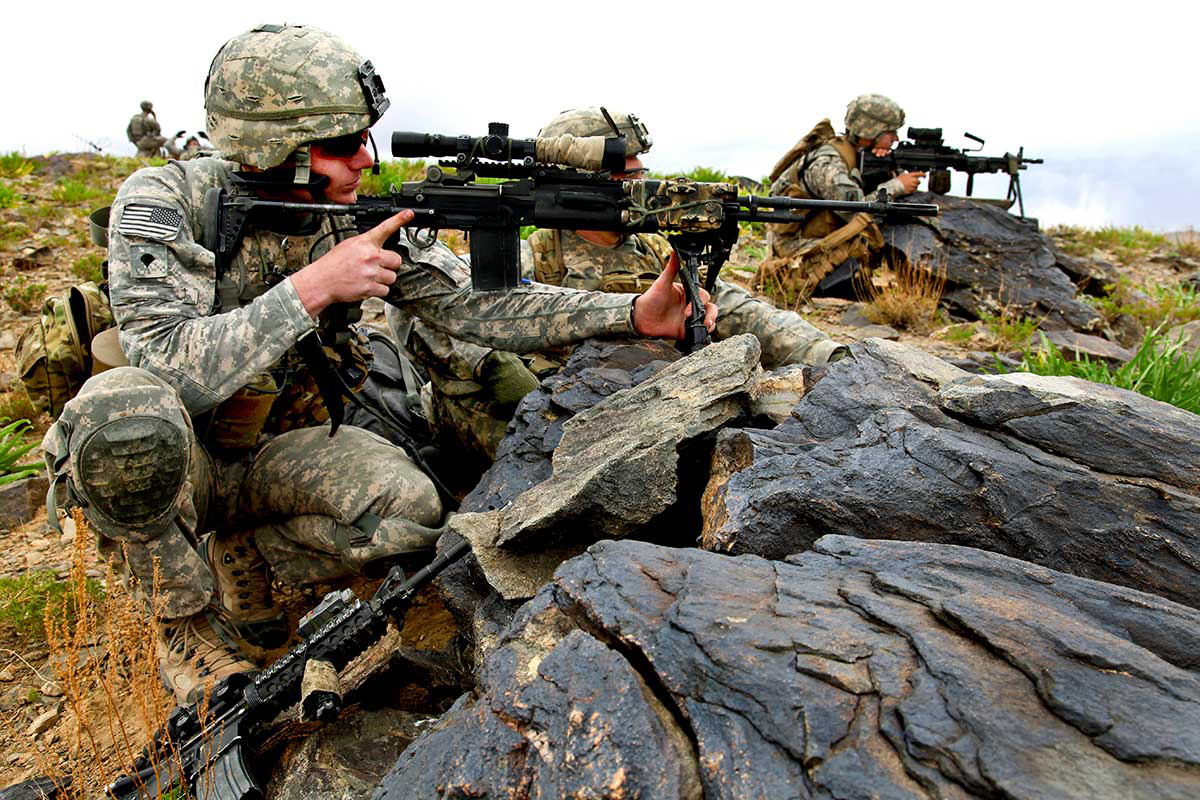 Soldiers provide security as a convoy passes through a valley
