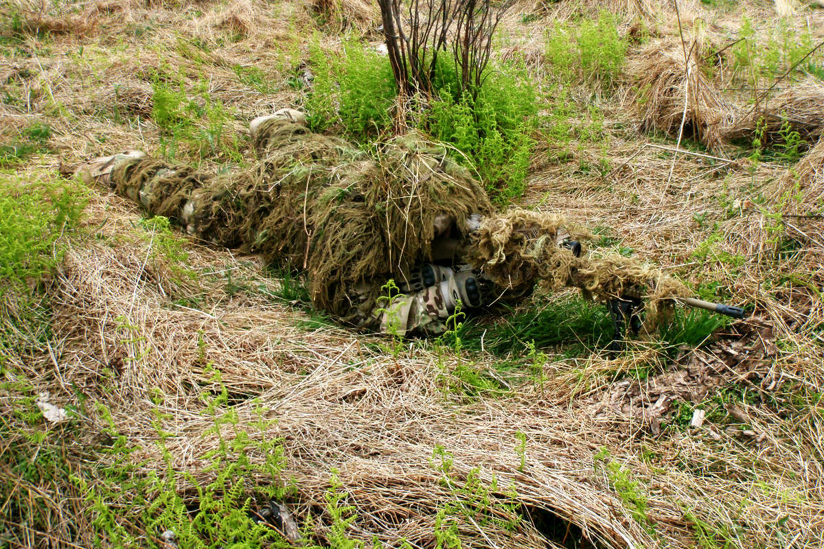 Infantry Soldier practices camouflage, cover and concealment.